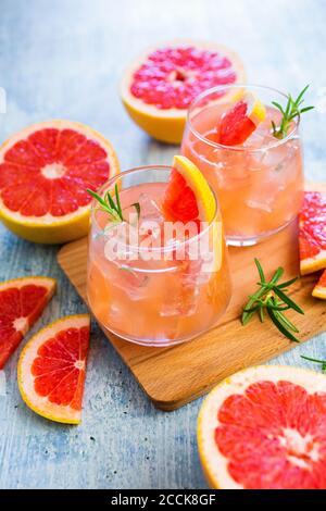 Gläser mit frischem Grapefruitsaft und Grapefruits Stockfoto