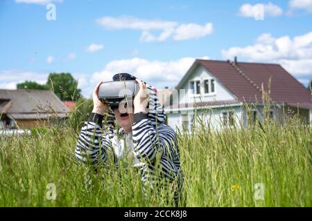 Junge trägt Zebra Kostüm mit VR-Simulator inmitten Gras in Stadt Stockfoto