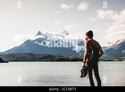 Mann mit Schuhen, der den Blick auf den Pehoe-See im Torres Del Paine Nationalpark, Chile Patagonien, Südamerika, bewundert Stockfoto