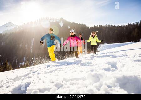 Gruppe unbeschwerter Freunde beim Laufen und Spaß im Schnee, Achenkirch, Österreich Stockfoto