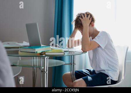 Depressive Schuljunge will nicht studieren, hat schlechte Noten in der Schule, Notizen in Tagebüchern lassen viel zu wünschen übrig Stockfoto