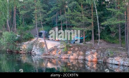 Camping am See. Blick auf das Ferienlager befindet sich am Rande des überfluteten Granitbruchs zwischen den Kiefern Stockfoto