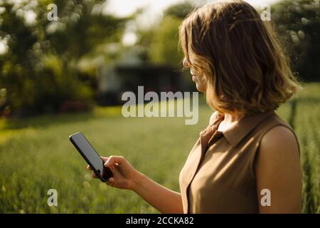 Junge Frau mit Handy auf dem Land Stockfoto