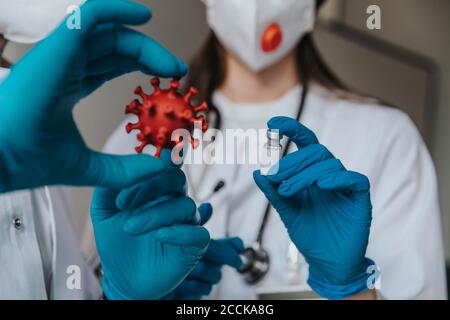 Nahaufnahme von Ärzten mit Impfstoff und biologischem Zellmodell Krankenhaus Stockfoto