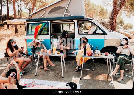 Frauen mit Schutzmasken während ihrer Reise mit dem Camper Stockfoto