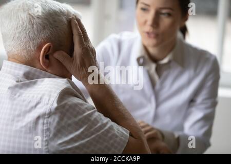 Gestresste ältere ältere Patienten beschweren sich über Migräne-Krankheit. Stockfoto