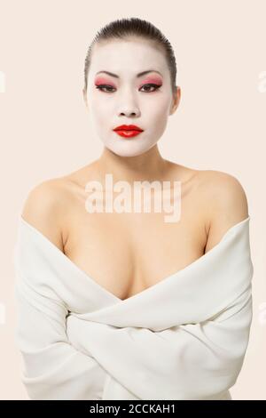 Junge Frau mit Opern-Make-up in Decke gegen Weiß gewickelt Hintergrund Stockfoto