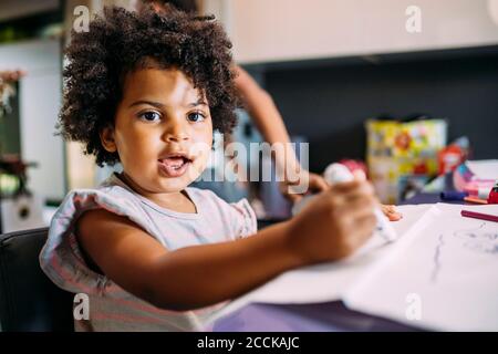 Nahaufnahme von niedlichen Baby-Mädchen Zeichnung auf Papier zu Hause Stockfoto