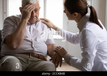 Ungesunde ältere Patienten beschweren sich über Kopfschmerzen. Stockfoto