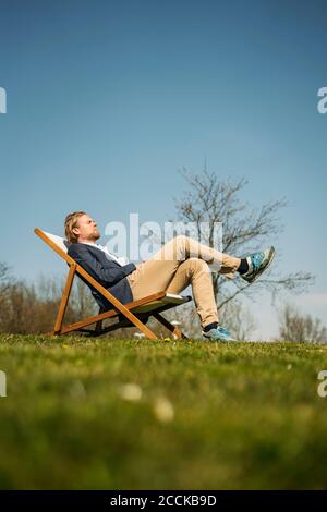 Blick auf die Oberfläche des männlichen professionellen Entspannung auf Stuhl parken Sie an sonnigen Tagen Stockfoto