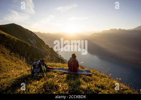 Wanderweibin, die während des Sonnenuntergangs am Aussichtspunkt sitzt, Augstmatthorn, Schweiz Stockfoto