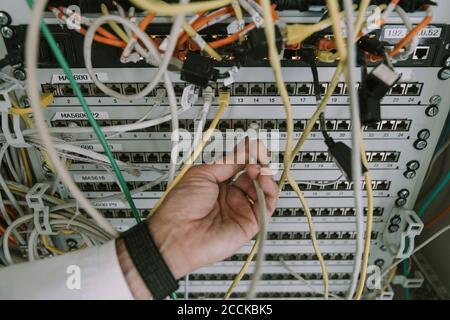 Nahaufnahme des manuellen Einsteckkabels im Rack des Rechenzentrums Stockfoto