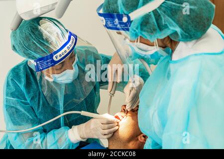 Ärztin und Krankenschwester, die die Patientin in der Zahnarztklinik untersucht Stockfoto