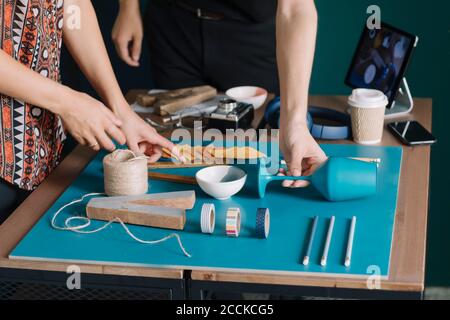 Nahaufnahme des kreativen Paares, das Dekoration auf dem Tisch arrangiert Stockfoto