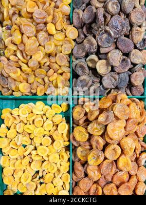 Getrocknete Aprikosen von vier verschiedenen Arten in einem Tablett zum Verkauf auf dem Markt. Getrocknete Früchte und gesunde Lebensmittel. Stockfoto