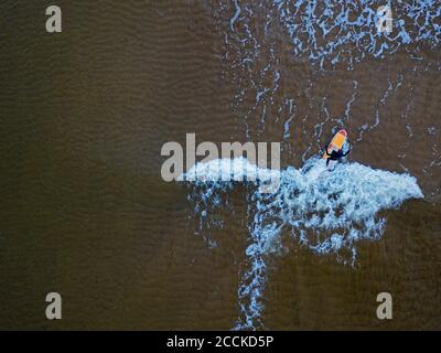 Luftaufnahme des Menschen Surfen in braunen Gewässern von Barents Meer Stockfoto