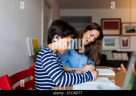 Tutorin erklärt ihren Schüler am Tisch zu Hause Stockfoto