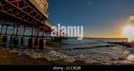 Fischaugen Blick vom Sandstrand neben dem viktorianischen Pier in der Stadt Cromer an der Nord Norfolk Küste bei Sonnenaufgang. Absichtlich Stockfoto