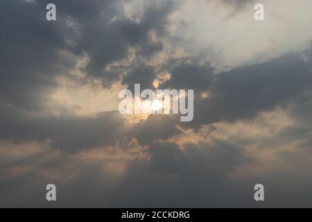 Schöner Abend blauer Himmel. Sonnenstrahlen scheinen durch Wolken. Natürlicher Hintergrund. Inspirierendes Konzept. Speicherplatz kopieren. Stockfoto