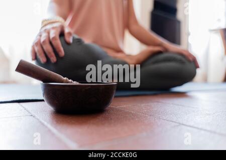 Frau macht Yoga zu Hause, singende Schüssel im Vordergrund Stockfoto