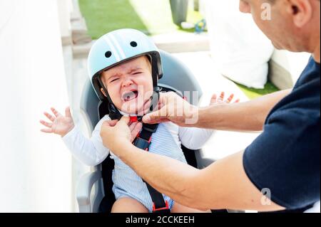 Vater mit Sohn sitzt in der Sicherheit Sitz des Fahrrads Stockfoto