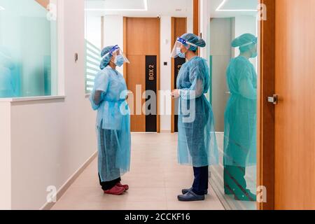 Weibliche Krankenschwestern diskutieren im Korridor des Krankenhauses Stockfoto