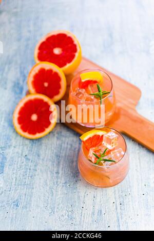 Gläser mit frischem Grapefruitsaft und Grapefruits Stockfoto