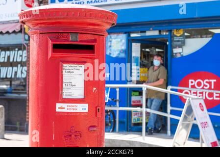 Vorrangiges Briefkasten, Schild, vor einem Postamt in Southend on Sea, Essex, Großbritannien, während COVID-19 Coronavirus Pandemiesperre. Person mit Gesichtsmaske Stockfoto