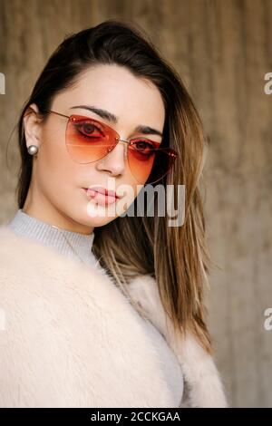 Modische junge Frau trägt Sonnenbrille in der Stadt Stockfoto