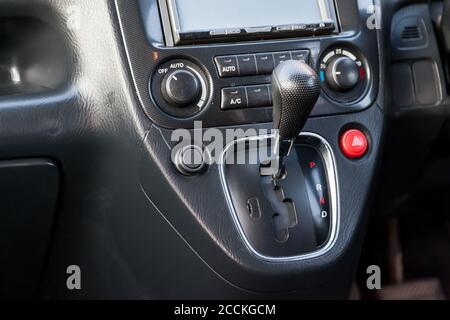 Automatikgetriebe Schaltknopf in einem schwarzen japanischen Auto auf der zentralen Steuerkonsole. Händlergarantie und Rückruf der Übertragung. Stockfoto
