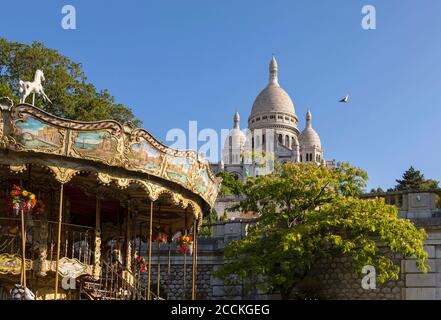 Karussell und Kirche gegen klaren blauen Himmel, Paris, Frankreich Stockfoto