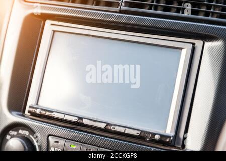 Die zentrale Bedienkonsole im Innenraum des Fahrzeugs mit einem Computerdisplay, einer Audioanlage und einem Radio in grauem und schwarzem Kunststoff. On-bo Stockfoto