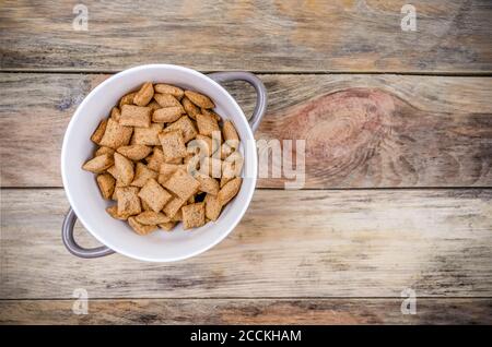 Schüssel mit süßen Maispfählen mit Schokolade innen auf einem Holzhintergrund, Kopierraum, Draufsicht Stockfoto