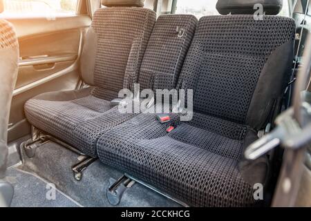 Reihe der Beifahrersitze mit dunkelgrauem, trocken gereinigtem Stoff bezogen; Vorbereitung eines alten japanischen Autos vor dem Verkauf. Stockfoto