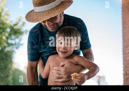 Kind mit seinem Großvater essen auf der Veranda des Hauses Stockfoto