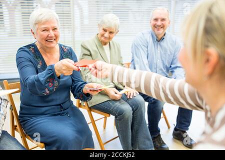 Senioren in Altersheim Teilnahme an Gruppentherapie mit bunten Papier Karten Stockfoto