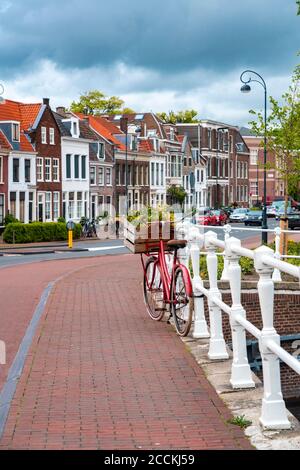 Niederlande, Nordholland, Haarlem, Fahrrad geparkt entlang Geländer der Kanalbrücke mit Häusern entlang Hooimarkt Straße im Hintergrund Stockfoto