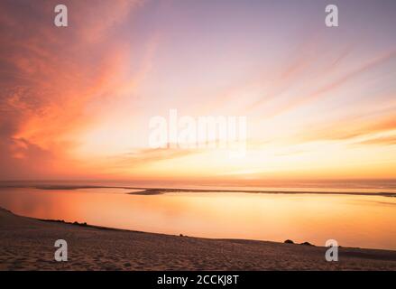Idyllischer Blick auf das Sonnenlicht, das sich am Atlantik gegen den Himmel bei Sonnenuntergang reflektiert, Düne von Pilat, Nouvelle-Aquitaine, Frankreich Stockfoto