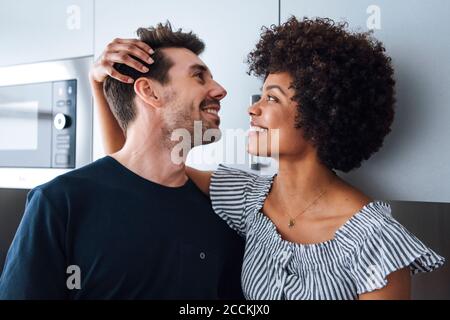 Glückliches multiethnisches Paar in der Küche Stockfoto