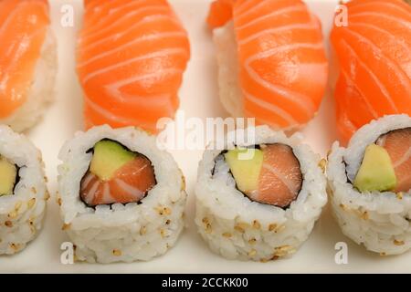 Sushi mit Lachs und Brötchen auf einem weißen Teller Stockfoto