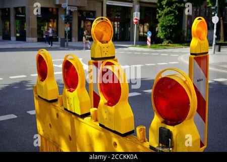 Gelbe Straßensperre mit roten Blinklichtern an einer Straße im Downdown Düsseldorf. Stockfoto