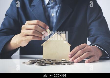 Hand of Business Mann mit Münze in Sparschwein mit Geldstapel wachsendes Wachstum Geld sparen, Konzept Invesment für finanzielle Freiheit Geschäft setzen. Stockfoto