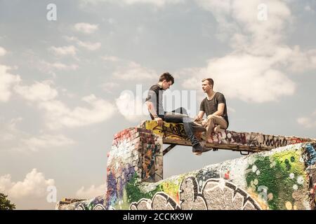 Zwei Jungen im Teenageralter hängen in einem alten heruntergekommenen Industriegebiet Stockfoto