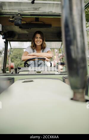 Porträt einer selbstbewussten jungen Frau in einem Traktor Stockfoto