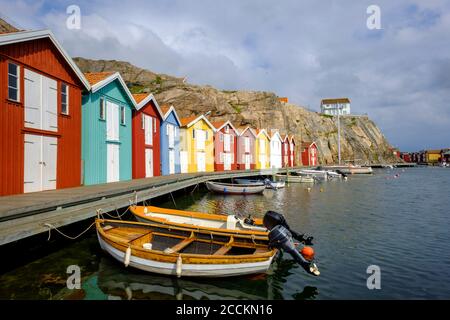 Schweden, Vastra Gotaland County, Smogen, Boote vor bunten Bootshäusern festgemacht Stockfoto