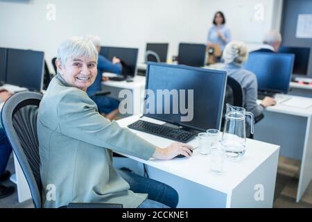 Selbstbewusste ältere Frau, die an einem Computerkurs teilnimmt Stockfoto