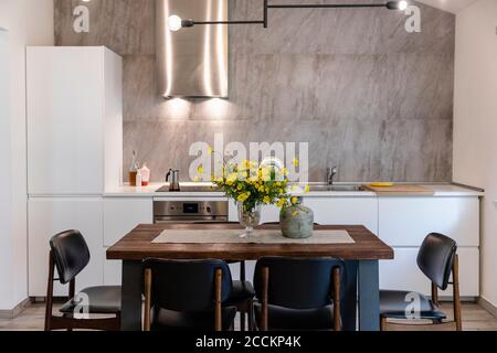 Esstisch mit Stühlen in moderner Küche zu Hause angeordnet Stockfoto