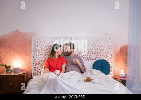 Romantisches Paar mit Frühstück auf dem Bett zu Hause Stockfoto