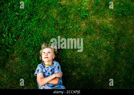 Lächelnder Junge auf Gras im Park liegend Stockfoto