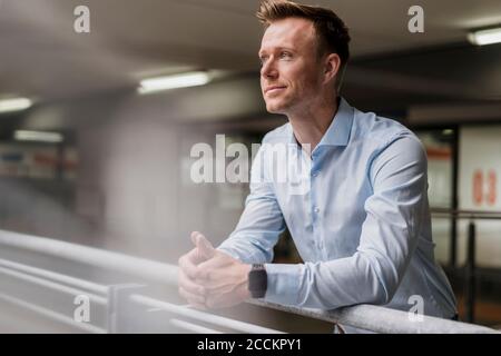 Lächelnd Geschäftsmann wegsehen in Stadt Stockfoto